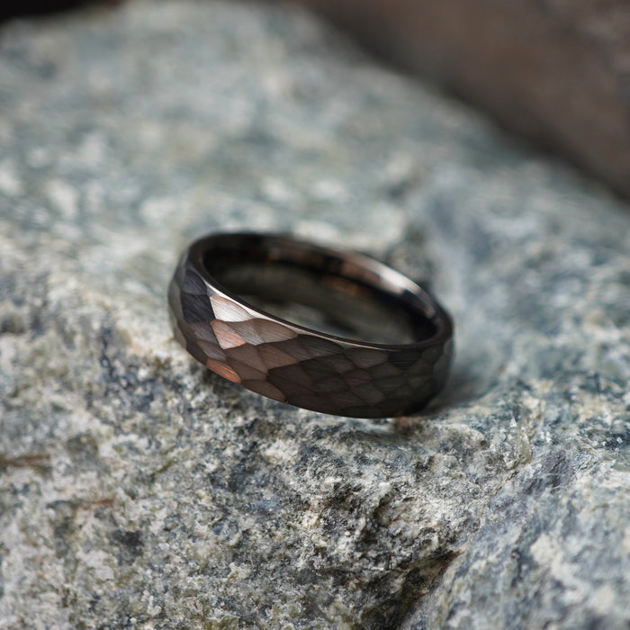The Anvil 6mm gunmetal tungsten ring on a stone background