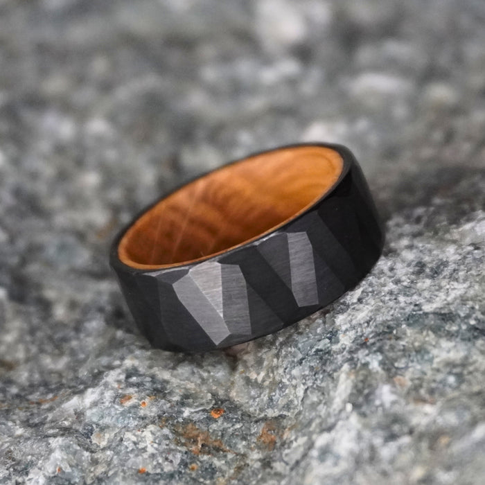 Black tungsten wedding band with an 8mm faceted design by Forge and Lumber.