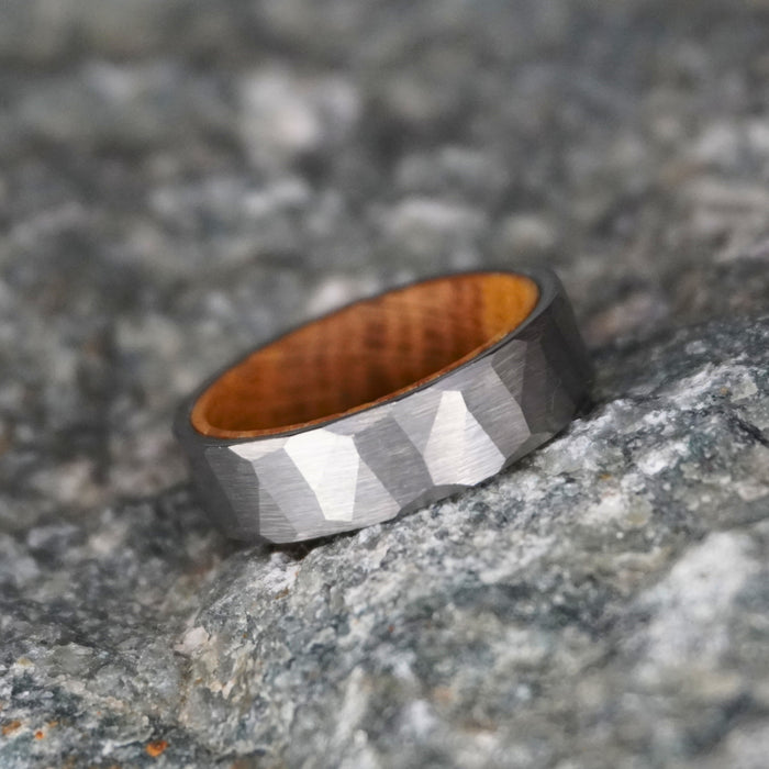 Durable barrel-inspired ring by Forge and Lumber, featuring a faceted grey exterior and wooden interior.