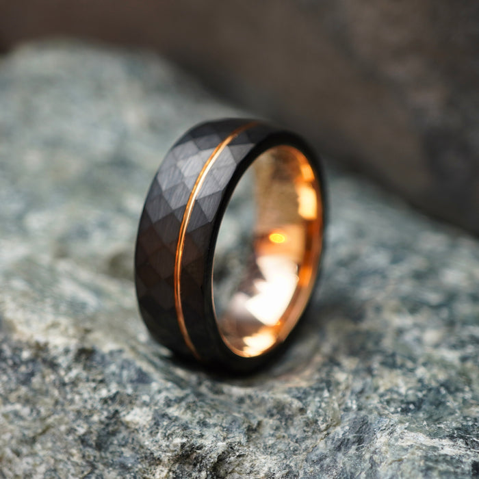 Black comfort-fit wedding band with textured surface and rose gold stripe by Forge and Lumber.