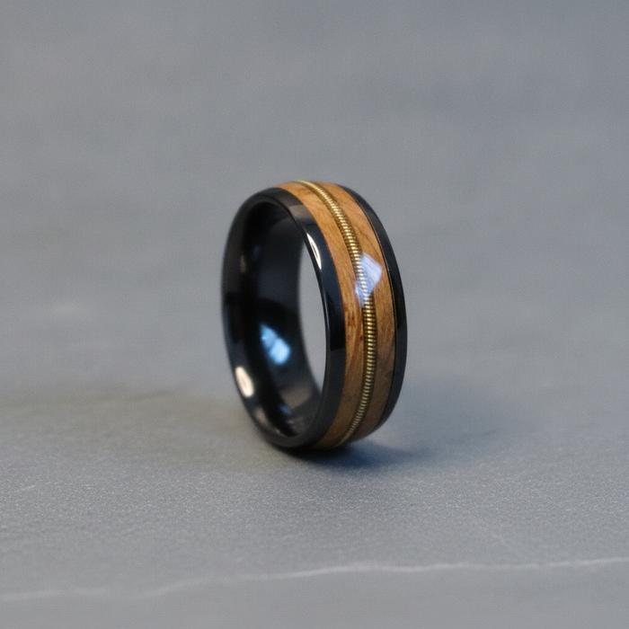 The Fret 8mm black tungsten ring with barrel oak and guitar string inlays