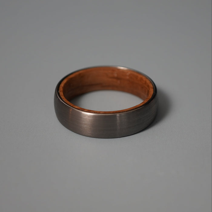 The Glen 6mm brushed tungsten band showing the oak barrel interior