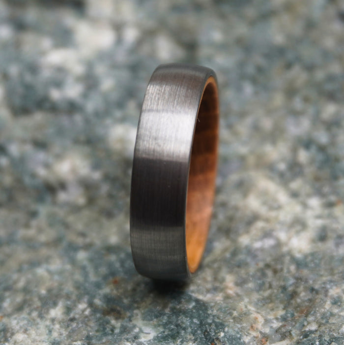 The Glen 6mm brushed tungsten ring with the oak barrel interior visible