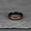 The Grain, a 4mm black plated tungsten band with a Koa wood inlay