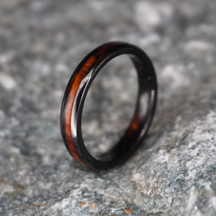 The Grain 4mm black tungsten band with a Koa wood inlay