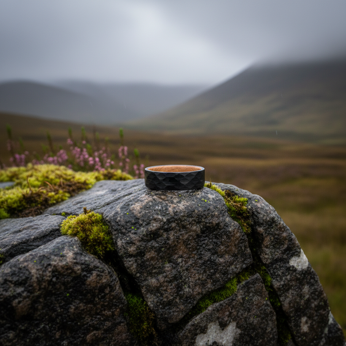 The Iona 8mm black tungsten band on a rugged outdoor backdrop
