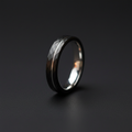 The Lode, a 4mm faceted black plated tungsten band with a bare tungsten pinstripe