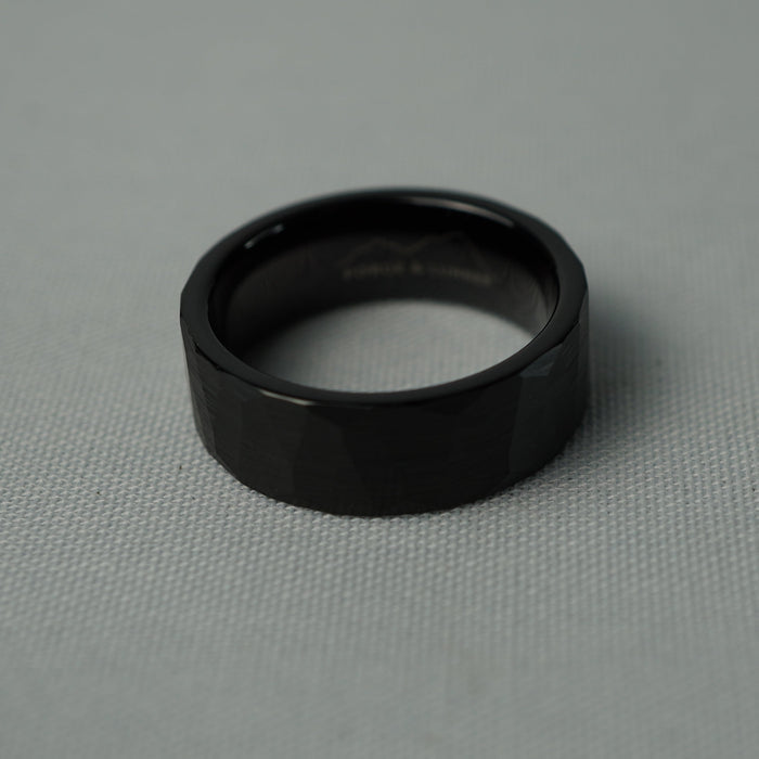 The Slate 8mm black tungsten ring on a grey fabric background