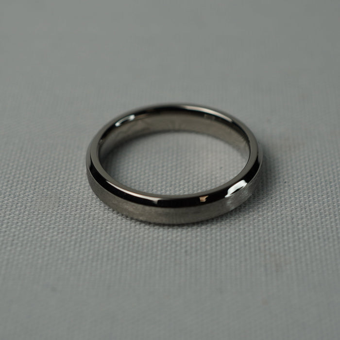 The Torque 4mm titanium ring on a grey textured surface