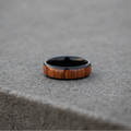 The Ukulele, an 8mm round-profile black plated tungsten band with a Koa wood inlay