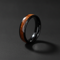 The Warrior, a 6mm round-profile black plated tungsten band with a Koa wood inlay